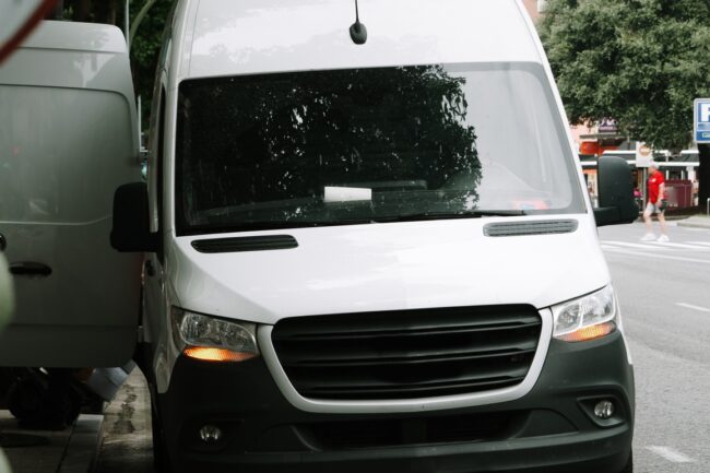 A delivery van stationary on the roadside in a city